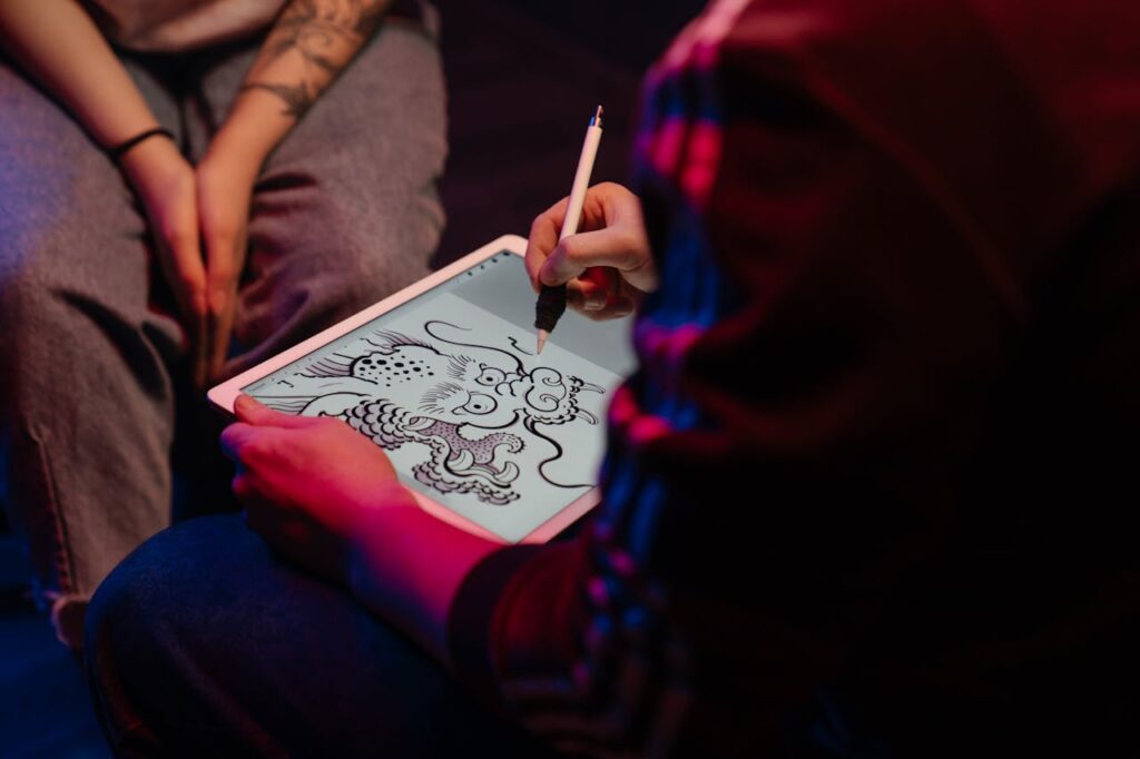 Artist creating a digital dragon tattoo design on tablet, emphasizing neon glow and creativity.